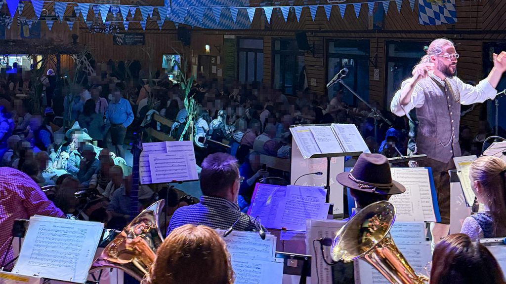 Blick von der Bühne - Sebastian Schertel beim Dirigieren im dunklen Licht - im Hintergrund das Publikum