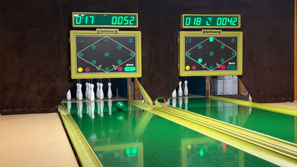 zwei Kegelbahnen mit einer rollenden Kugel